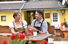 Ein Pärchen auf der Terrasse vom Almgasthaus Puster am Madereck