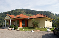 Das Café am Golfplatz in Oberaich, ein gelb-oranges Häuschen, modern und einladend, dahinter der Wald