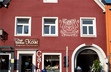 Die Bäckerei Koini, das rote Gebäude von außen, modern, mit weißen Fenstern