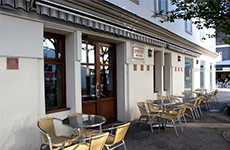 Das Lokal Life Style, in der Burggasse, weißes Gebäude mit Tischen und Sesseln im Freien und brauner Eingangstür