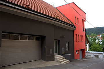 Das Gebäude des Appartements Haberl, ein modernes, rotes Gebäude mit Terrasse