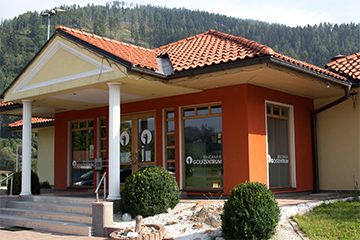Das Café am Golfplatz in Oberaich, ein gelb-oranges Häuschen, modern und einladend, dahinter der Wald