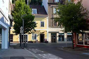 Die Fuchs J. Bäckerei, typisches, gelbes Haus mit Logo der Bäckerei