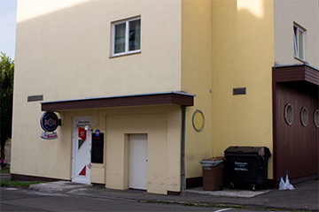 Das Kommunikationscafé "Zur Rederei", der Eingang in einem Wohnhaus im Erdgeschoss, liegend in der Paulahofsiedlung