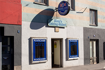 Das Café Konni's Ostringstüberl, in einem blau-orange gestreiftes Gebäude in der Herzog-Ernst-Gasse