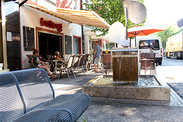 Das Café Liebling Kost.Bar in der Mittergasse, weißes Gebäude mit roten Akzenten und einen weißen Sonnenschutz