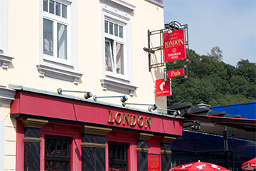 Das London Pub in der WieneLondon - Pub - Café, typisch englisches Gebäude, roter Unterteil mit der Aufschrift London und daneben eine typisch englische Telefonzelle