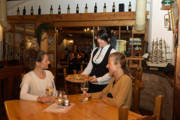 Die Pizzeria San Marco in der Mittergasse zwei Damen bekommen von der netten Kellnerin eine Pizza