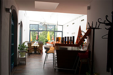 Ein Blick in das Restaurant mit einer Bar und hellem, einladenden Raum, und auf die große Terrasse