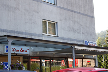 Das Café - Restaurant "Zum Ernstl", graues Haus in ruhiger Lage mit vielen Parkplätzen und Überdachung