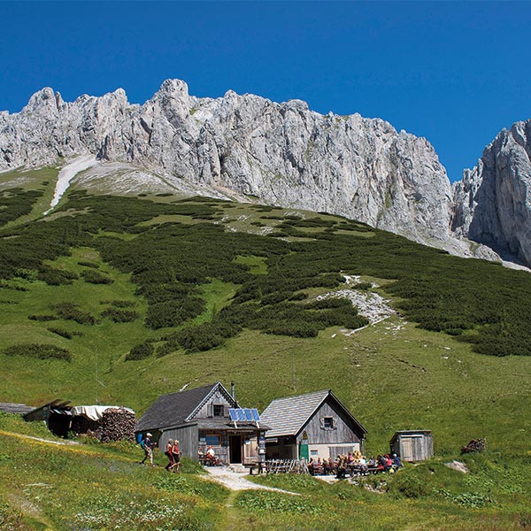Berghütte mit Berg im Hintergrund.